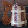 Tankard was crafted and carved by Dave Kiil on the occasion of the Estonian-Canadian Centennial in Stettler, Alberta in 1999. The shape of the handle and the carvings on the lid and the tankard depict symbolic Estonian patterns.