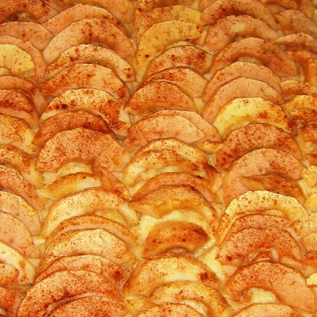 Apple slices are arranged on a bottom crust in a deep dish pan and baked to perfection.